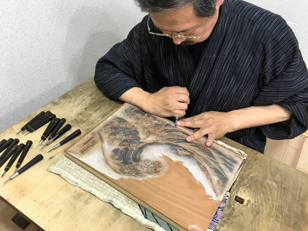 Artist carving a woodblock in the ukiyo-e style
